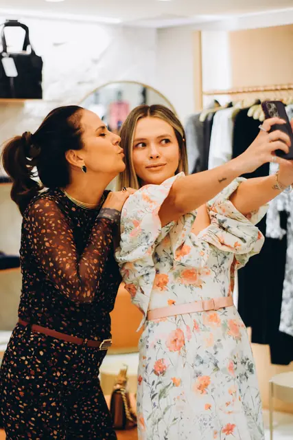 Duas mulheres fazendo selfie durante evento em loja